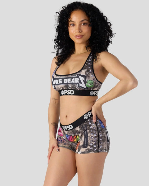 Woman wearing Care Bears Headbanger printed sports bra and shorts set with PSD branding.