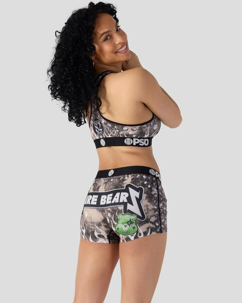 Woman wearing Care Bears-themed sports bra and shorts with animal print and graphic design.