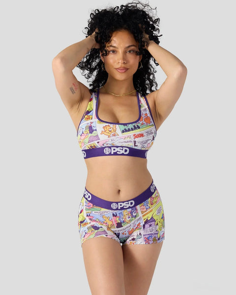 Woman wearing colorful comic-print sports bra and shorts set with purple PSD waistband and halter straps.