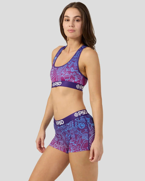 Woman wearing purple Rick and Morty patterned sports bra and shorts with PSD branding.