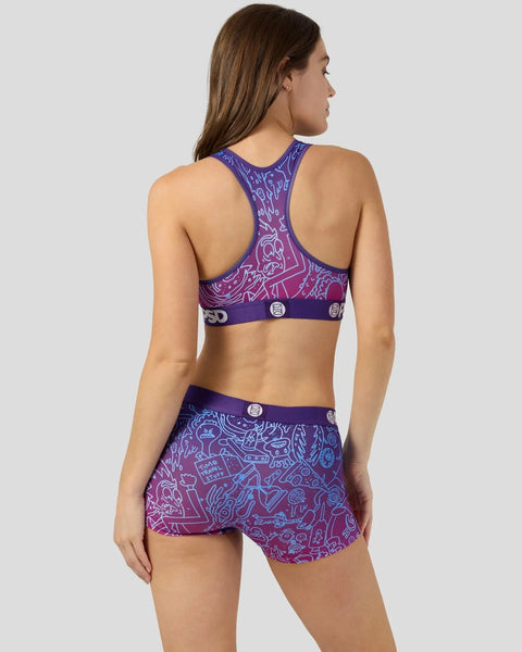 Purple and magenta sports bra and shorts set with all-over cartoon character pattern and circular logo details.
