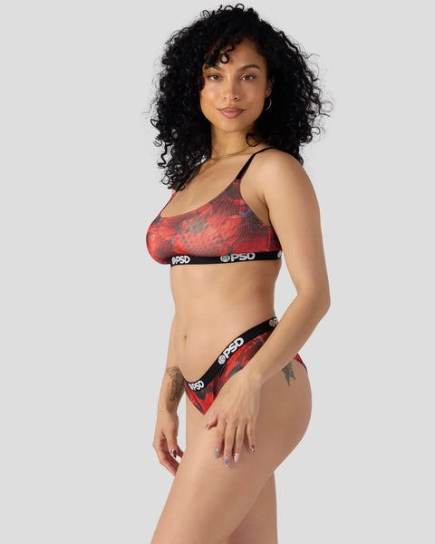 Woman wearing red and black patterned sports bra and matching briefs with PSD branding.