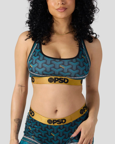 Teal sports bra with geometric pattern, black trim, and yellow PSD brand waistband.