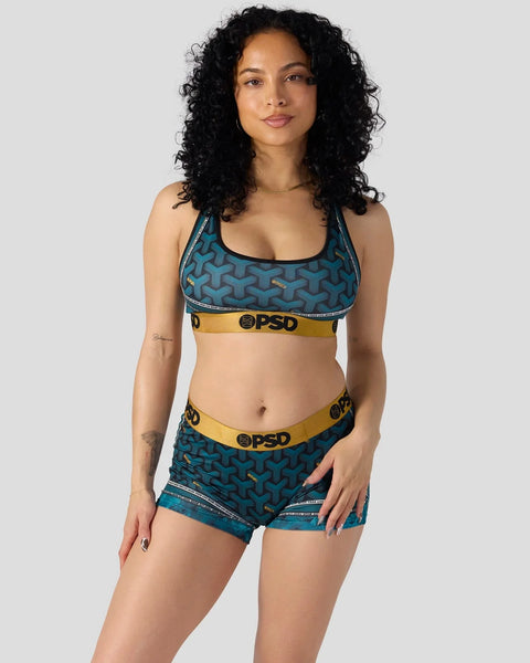 Teal sports bra and shorts set with geometric pattern and yellow waistband trim.