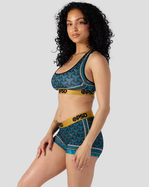 Teal sports bra and shorts set with geometric pattern and yellow elastic waistband with branding.