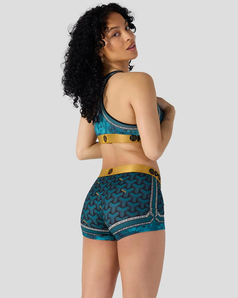 Teal patterned sports bra and shorts set with gold waistbands and decorative stitching details.