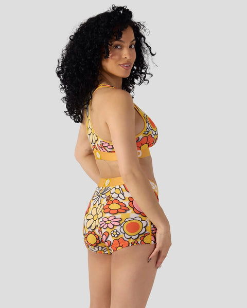 Two-piece swimsuit with yellow, orange, and red floral print on matching bikini top and high-waisted shorts.