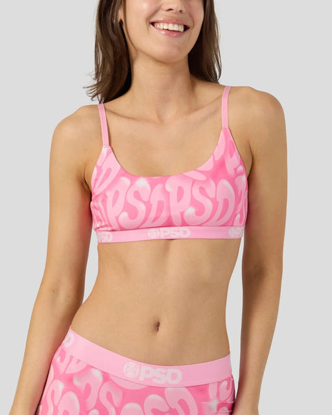 Woman wearing pink sports bra with repeated text pattern and matching pink underwear.