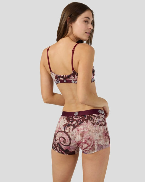 Woman wearing burgundy and pink jacquard patterned bra and matching shorts with floral design.