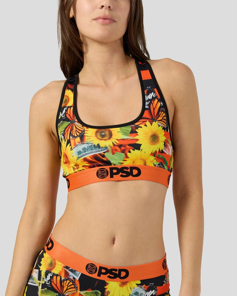 Racerback sports bra with sunflower and butterfly print, orange PSD waistband, and black trim.