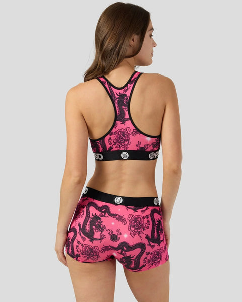 Hot pink sports bra and shorts set with black dragon and floral print and black trim bands.