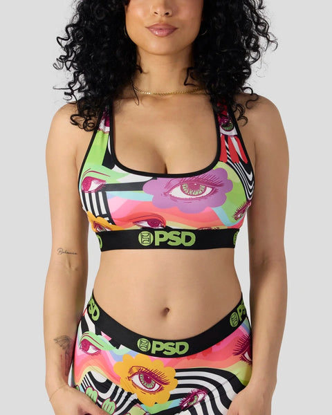 Woman wearing colorful eye-print PSD sports bra and matching underwear with black elastic waistband.