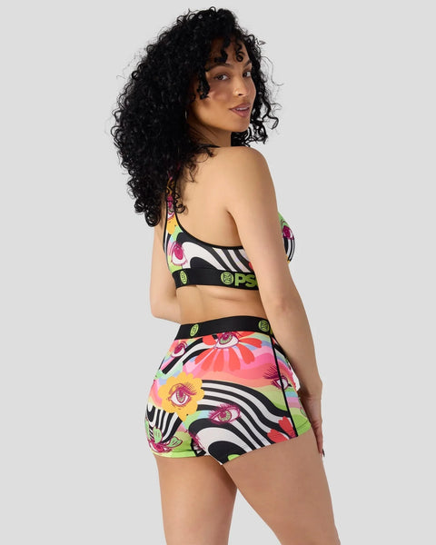 Woman wearing colorful floral and zebra-striped two-piece swimsuit with black trim, shown from behind.
