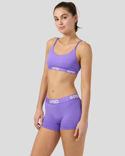 Woman wearing purple sports bra and matching shorts with PSD waistband.