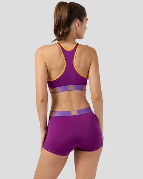 Purple sports bra and shorts set with yellow trim and purple waistband with logo detail, shown from back.