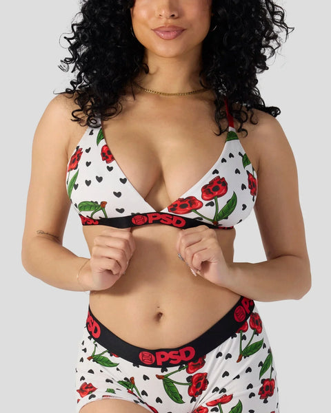 White bra and shorts set with red cherry and black heart print, black waistband with logo detail.