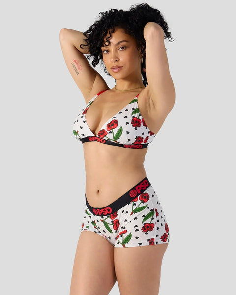 Woman wearing white modal bikini set with red rose and black heart print and black trim.