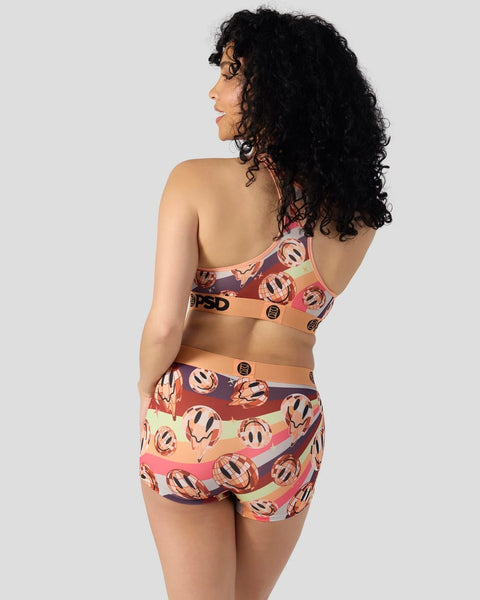 Three-piece set with patterned sports bra and matching briefs in dark jewel tones with circular motifs and striped bands.