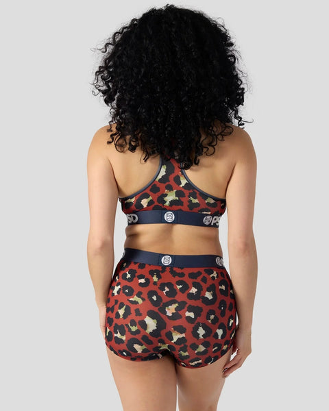 Red leopard print sports bra and shorts set with navy trim and circular buckle details, shown from back.