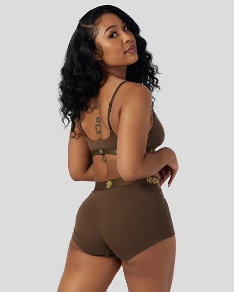 Woman wearing cocoa brown ribbed bra and shorts set with gold hardware details.
