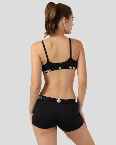 Woman wearing black modal bra and shorts set with branded waistband, shown from back.