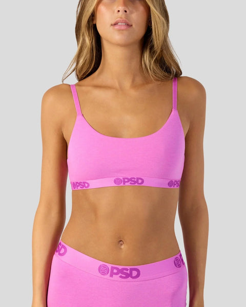 Woman wearing bright pink sports bra and matching underwear with branded waistband.