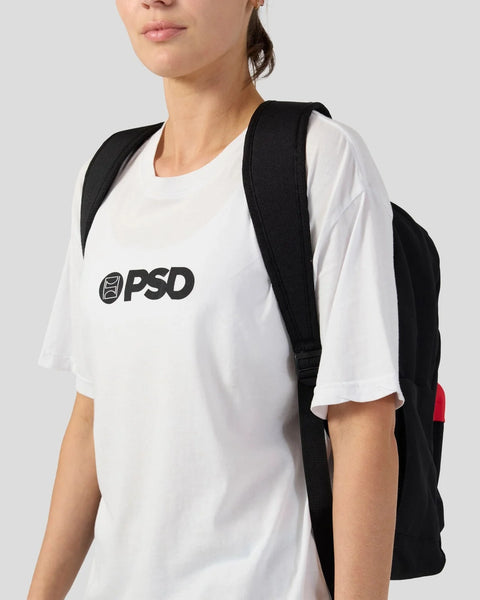 Black backpack with padded shoulder straps, worn over white shirt, visible red accent panel on side.