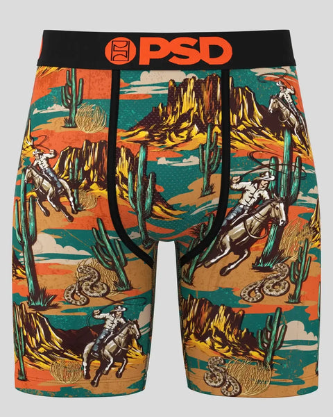 PSD brand boxer shorts with desert landscape print featuring cowboys, cacti, rock formations, and rattlesnakes in orange, tea