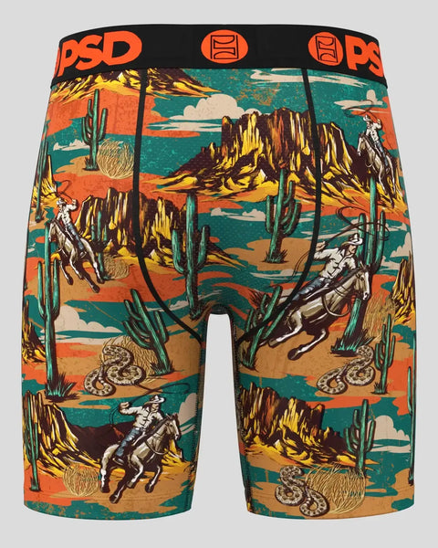 PSD boxer briefs with desert landscape print featuring cowboys, cacti, mountains, and snakes in orange, teal, and brown tones