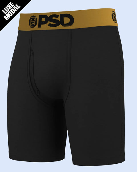 Black boxer briefs with gold PSD waistband and logo on light background.