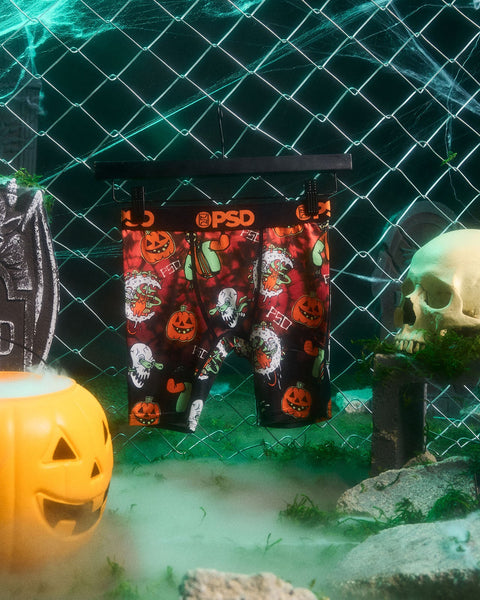 PSD brand underwear with red Halloween pattern featuring jack-o'-lanterns, ghosts, and pumpkins on dark background.