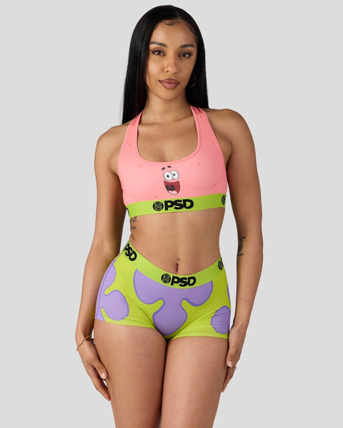 Woman wearing pink sports bra with Patrick character print and lime green shorts with purple starfish pattern and PSD waistba
