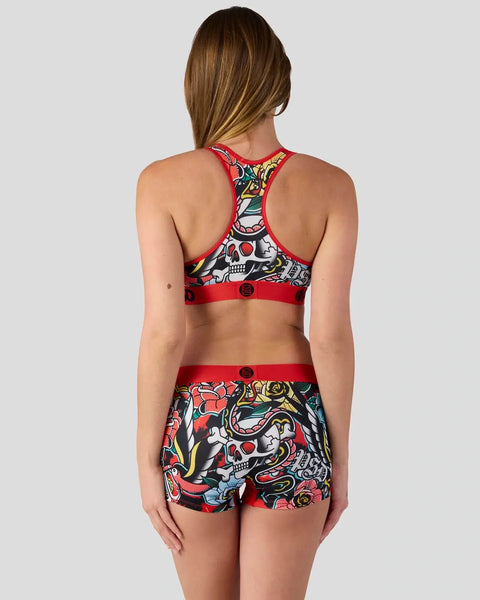 Red and black sports bra and shorts set with skull and floral tattoo-style print and red bands.