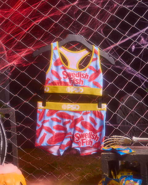 Swedish Fish themed tank top and shorts set with red candy print and yellow PSD waistband on hanger.