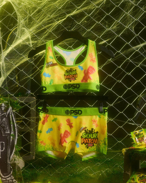 Yellow and green Sour Patch Kids underwear set with colorful candy print and PSD waistband displayed on hanger.