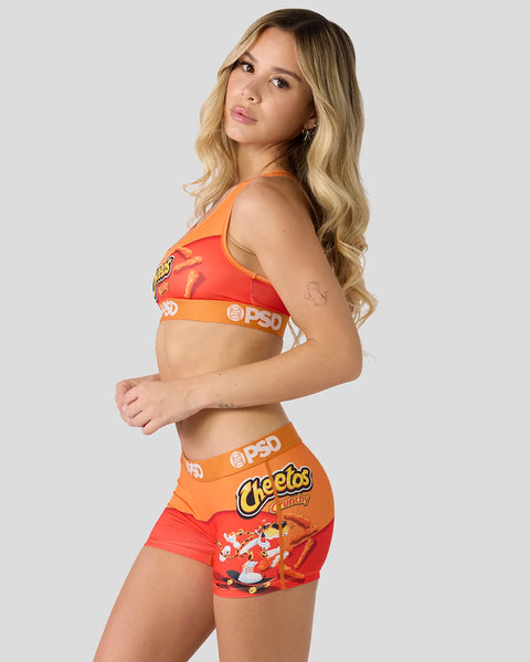 Woman wearing red and orange Cheetos-branded sports bra and shorts set with PSD waistband.