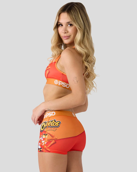 Woman wearing orange and red Cheetos Crunchy branded sports bra and shorts set with product logo.