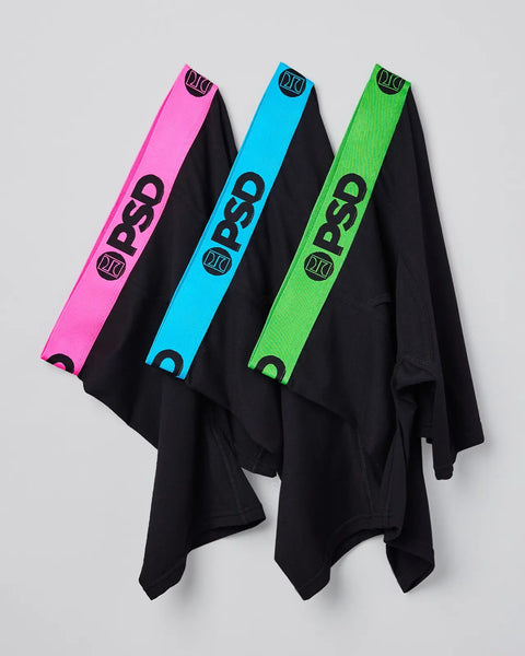 Three neon pink, blue, and green modal fabric pieces with black bodies and branded waistbands displayed draped.