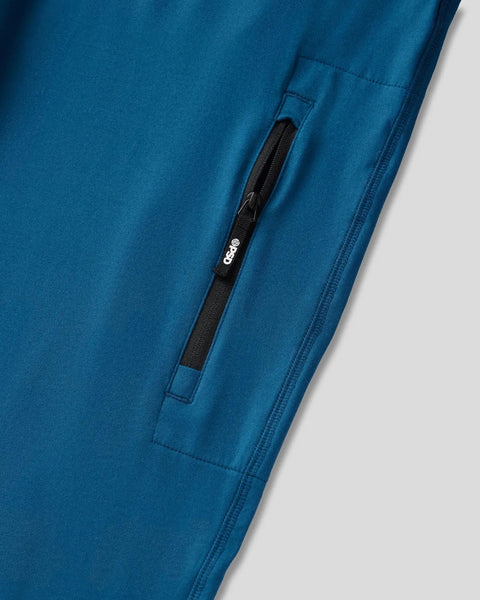 Deep teal jogger with black zipper pocket and seam details on leg.