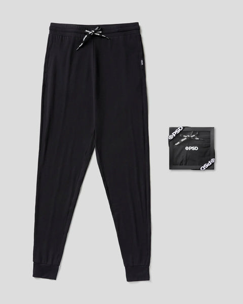 Black joggers with drawstring waistband, side pockets, and ribbed cuffs, displayed flat with packaging box.
