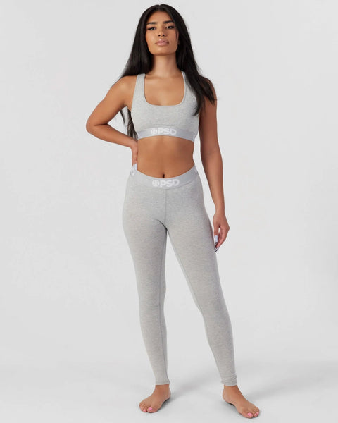 Woman wearing light grey racerback sports bra and matching leggings with white waistband branding.