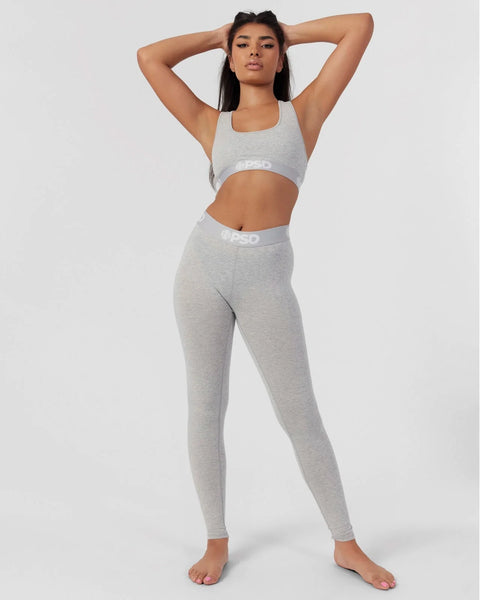 Woman wearing grey athletic crop top and matching leggings with branded waistband.