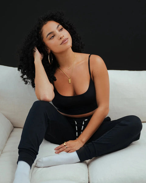 Black joggers with drawstring waistband and cuffed ankles, styled with a black crop top and white crew socks.