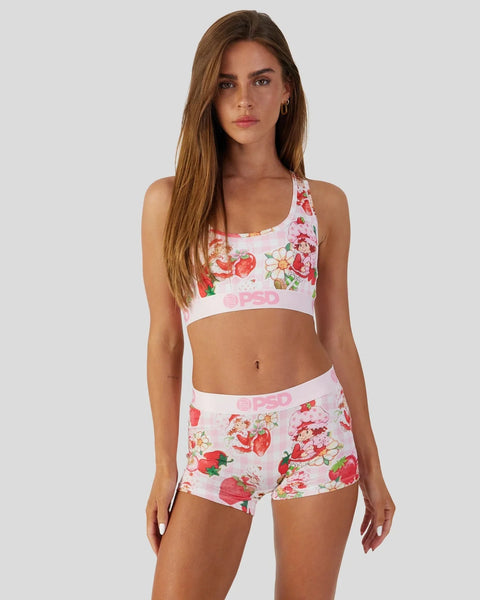 Woman wearing white sports bra and matching shorts with red strawberry and floral print.