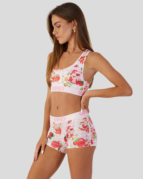 Strawberry and floral print two-piece swimsuit with white trim and pink bow details on matching bikini top and shorts.