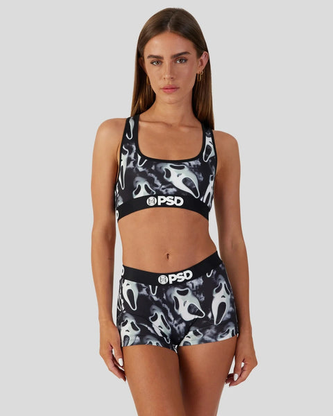 Woman wearing black and white ghost face print sports bra and matching shorts with PSD branding.