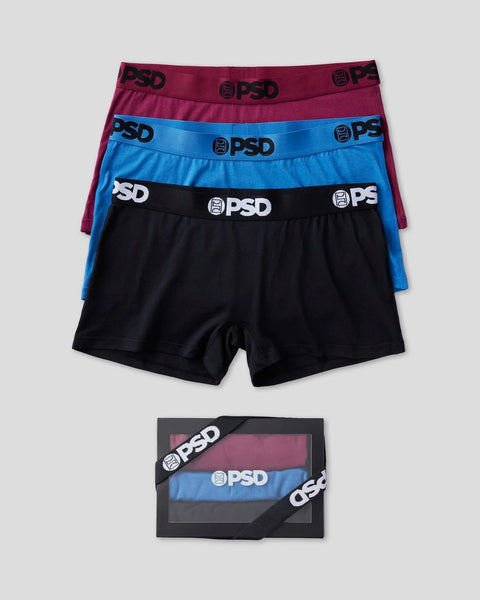 Three-pack of solid color boxer briefs in burgundy, blue, and black with PSD branded waistbands, shown stacked and in packagi