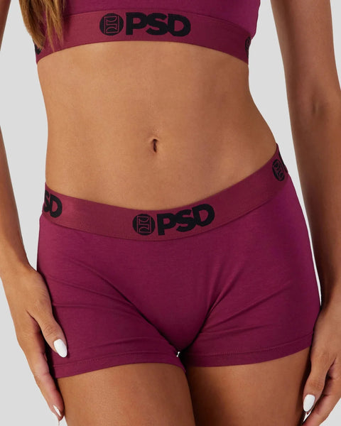 Purple PSD sports bra and shorts set with logo waistband displayed on model.