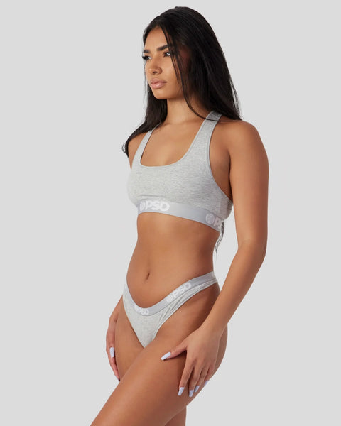 Woman wearing light grey athletic sports bra and matching underwear with branded waistband.