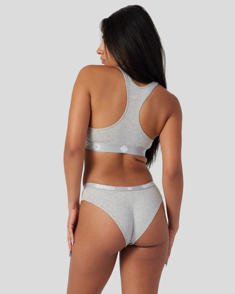 Woman wearing light grey racerback sports bra and matching briefs with grey waistband, shown from back.
